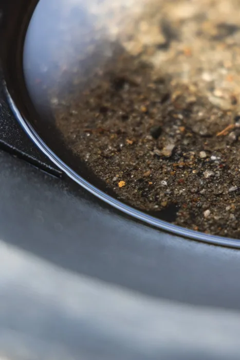 Natural gold nugget resting on soil
